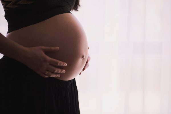 une femme enceinte tient son ventre après un test de paternité prénatal