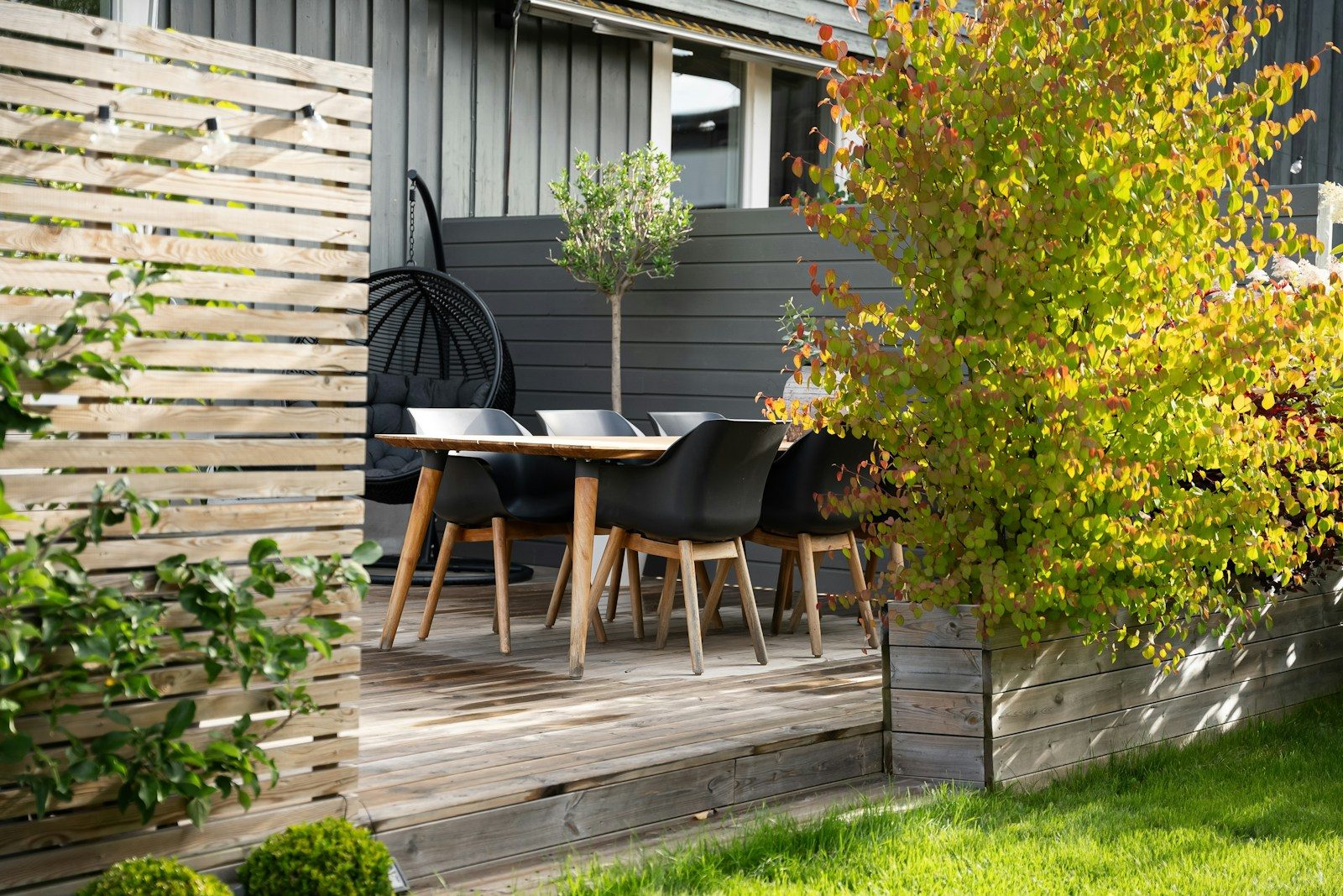 A patio with a table and chairs next to a fence
