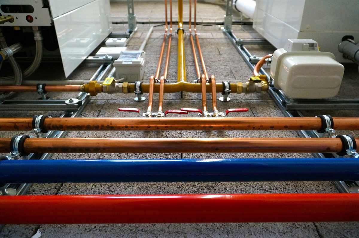 Tuyaux colorés, vannes et manifold sur sol bétonné Tuyaux colorés, vannes et manifold sur sol bétonné